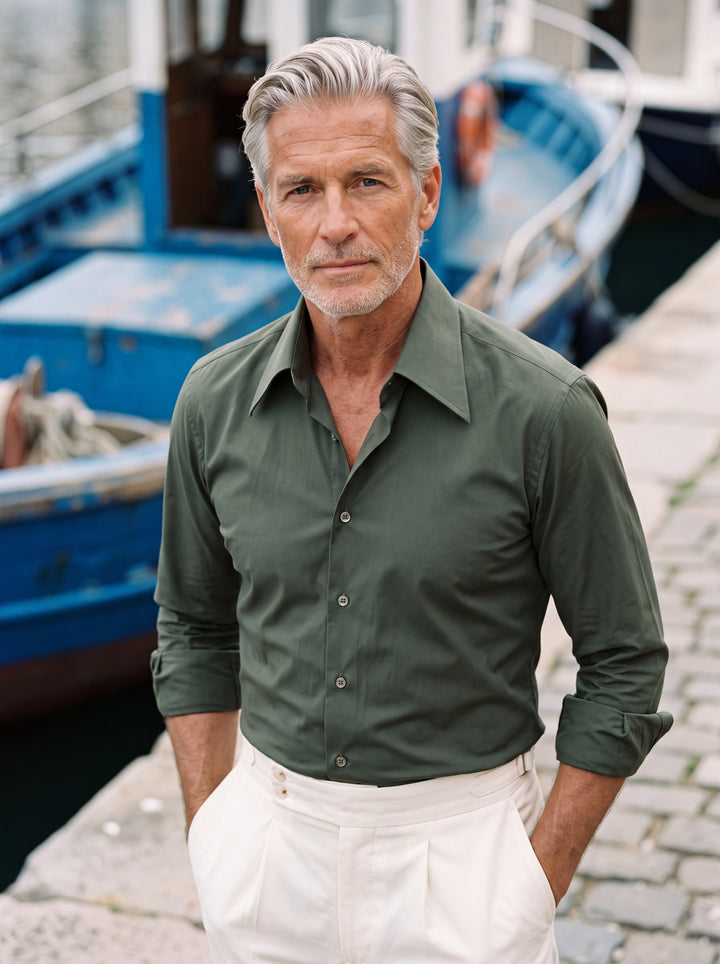 Dallas dress shirt in Olive, worn by a model on a quayside beside a fishing boat - Gentlemens Manor