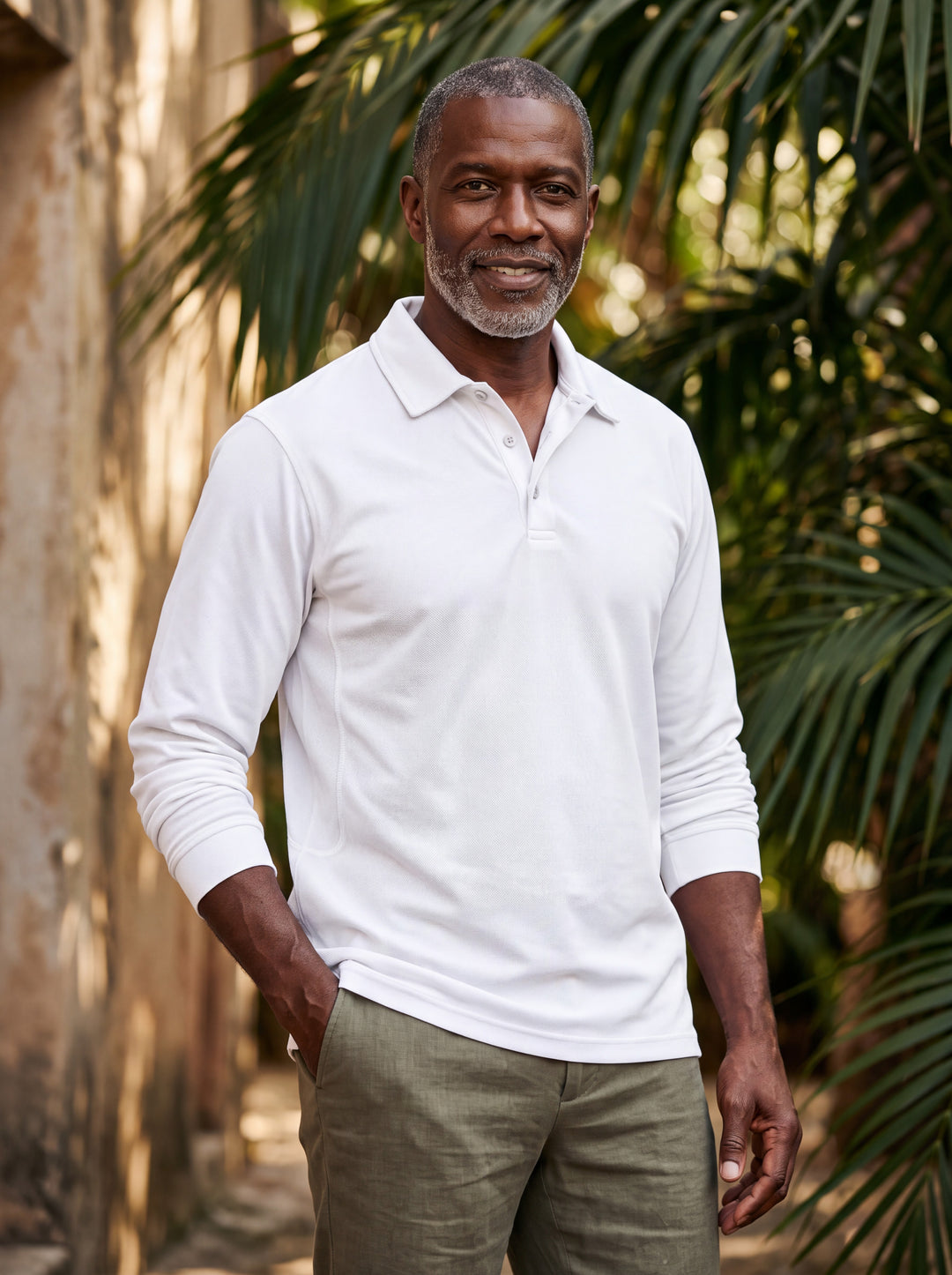 Dalton Men polo shirt in white, worn by a model on a Mediterranean terrace - Gentlemens Manor lifestyle