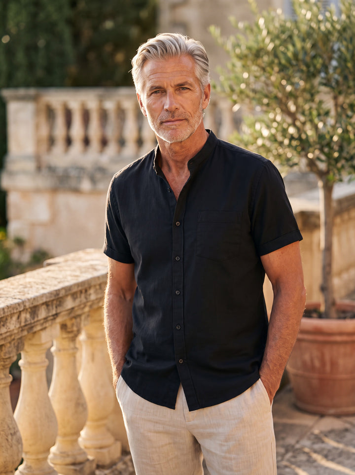 Dana Men short sleeve shirt in black, worn by a model on a Mediterranean terrace - Gentlemens Manor lifestyle