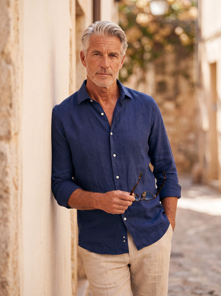 Dane Men linen shirt in Navy, worn by a model on a Mediterranean terrace - Gentlemens Manor lifestyle