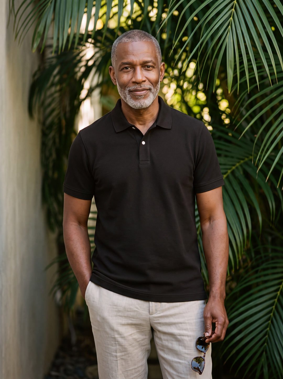 Dudley Men polo shirt in black, worn by a model on a Mediterranean terrace - Gentlemens Manor lifestyle