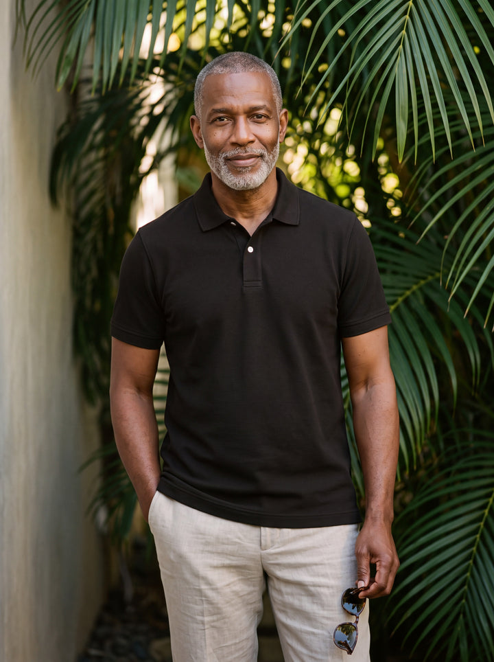 Dudley Men polo shirt in black, worn by a model on a Mediterranean terrace - Gentlemens Manor lifestyle