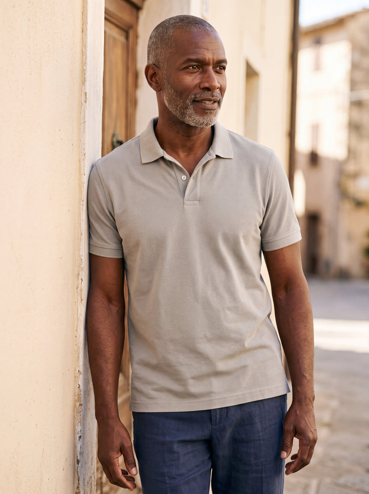 Dudley Men polo shirt in grey, worn by a model on a Mediterranean terrace - Gentlemens Manor lifestyle