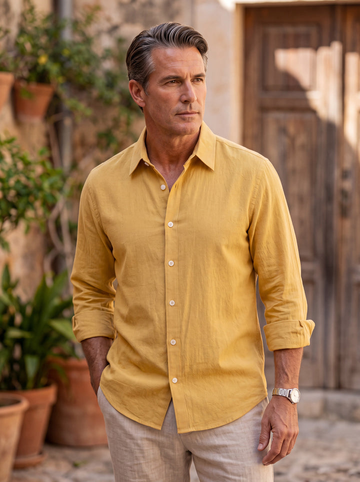 Elias Men dress shirt in Mustard, worn by a model on a Mediterranean terrace - Gentlemens Manor lifestyle