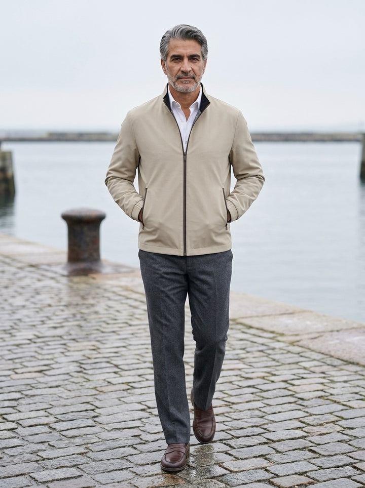 Elliot lightweight stand collar jacket in Sand, lifestyle on a stone harbor quay, Gentlemens Manor