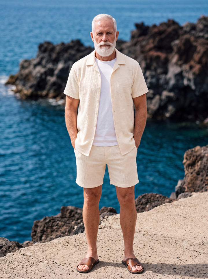Emmett Men two-piece summer set in cream, worn by a model in a Mediterranean setting - Gentlemens Manor lifestyle
