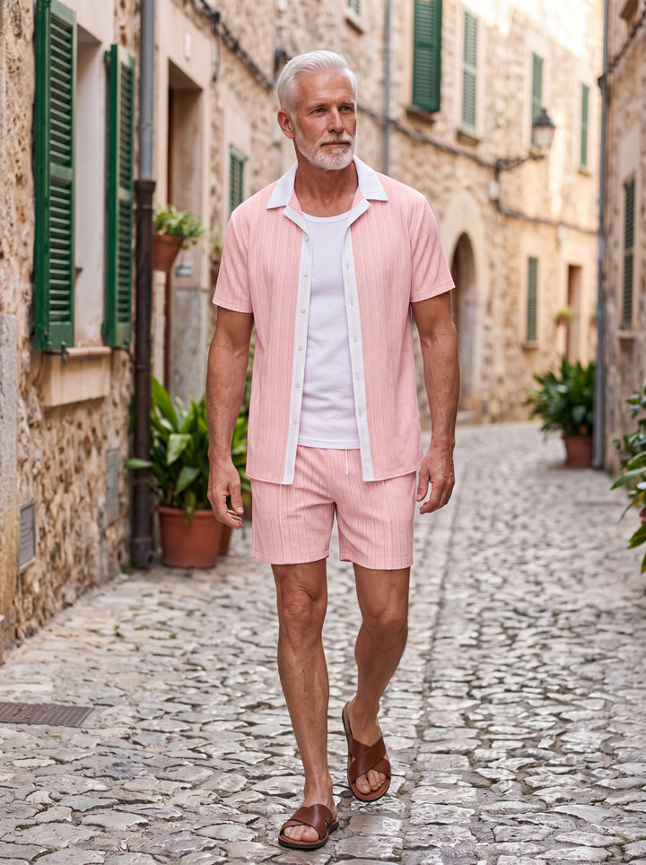 Ethan Men two-piece summer set in pink, worn by a model in a Mediterranean setting - Gentlemens Manor lifestyle