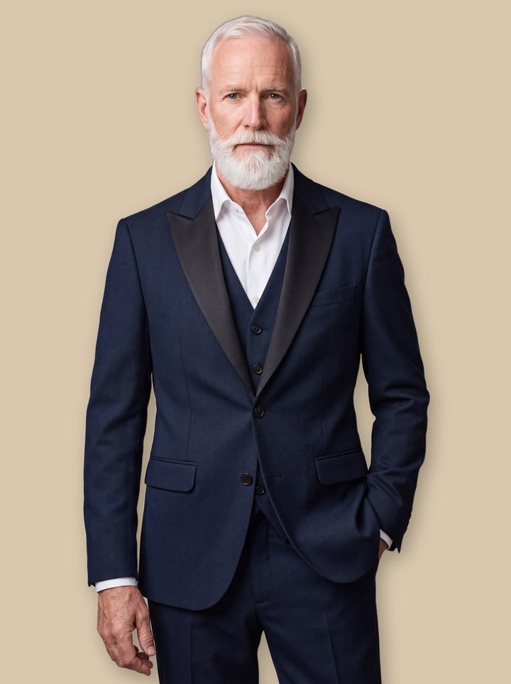 Floyd three-piece suit in Navy, worn by a model on a warm sand studio background - Gentlemens Manor