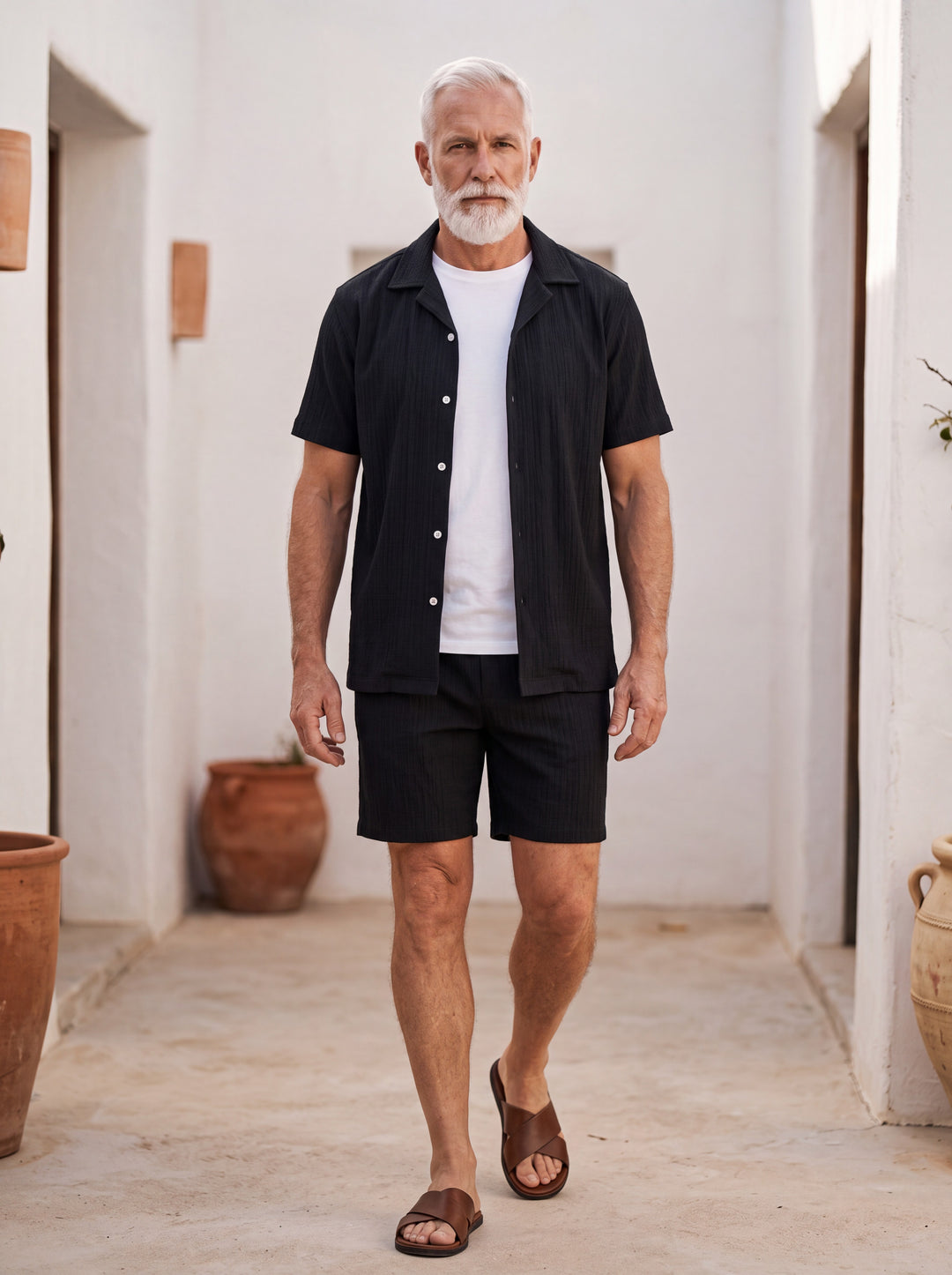 Gabriel Men two-piece summer set in black, worn by a model in a Mediterranean setting - Gentlemens Manor lifestyle