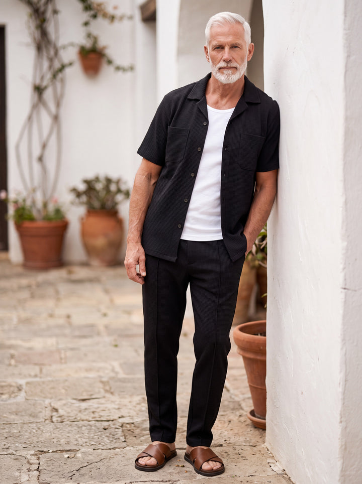 Gideon Men two-piece summer set in black, worn by a model in a Mediterranean setting - Gentlemens Manor lifestyle
