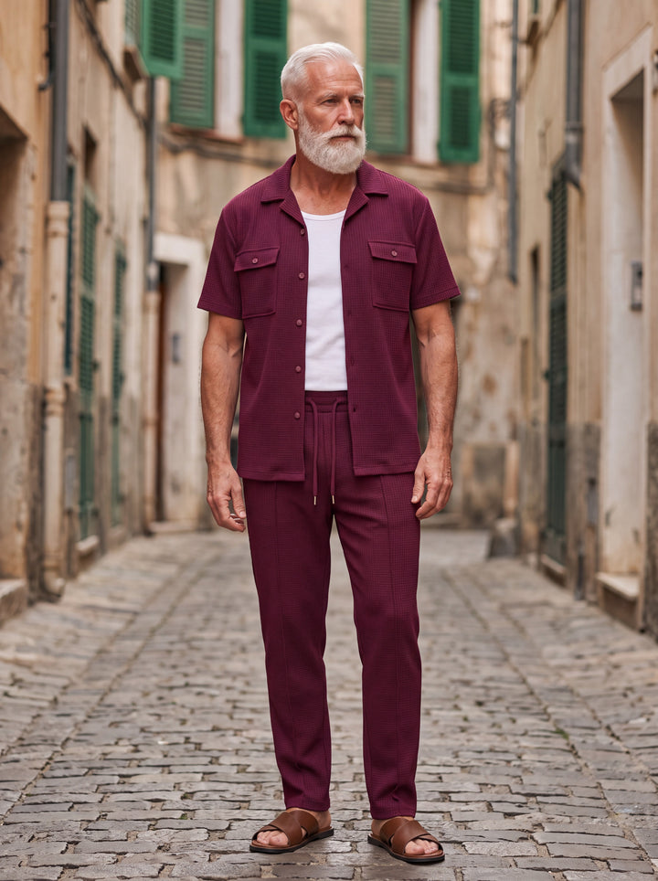 Gideon Men two-piece summer set in burgundy, worn by a model in a Mediterranean setting - Gentlemens Manor lifestyle