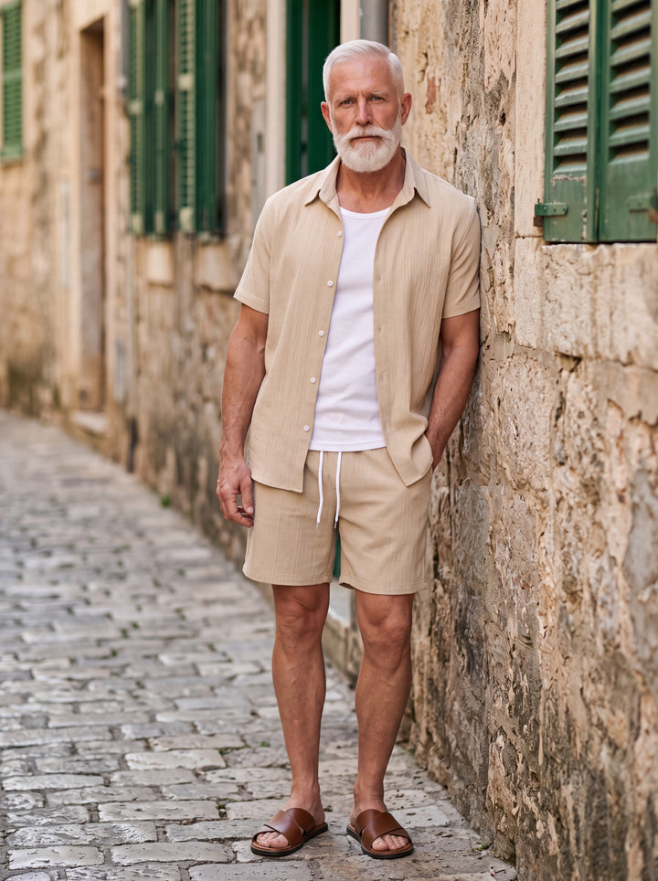 Gordon Men two-piece summer set in sand, worn by a model in a Mediterranean setting - Gentlemens Manor lifestyle