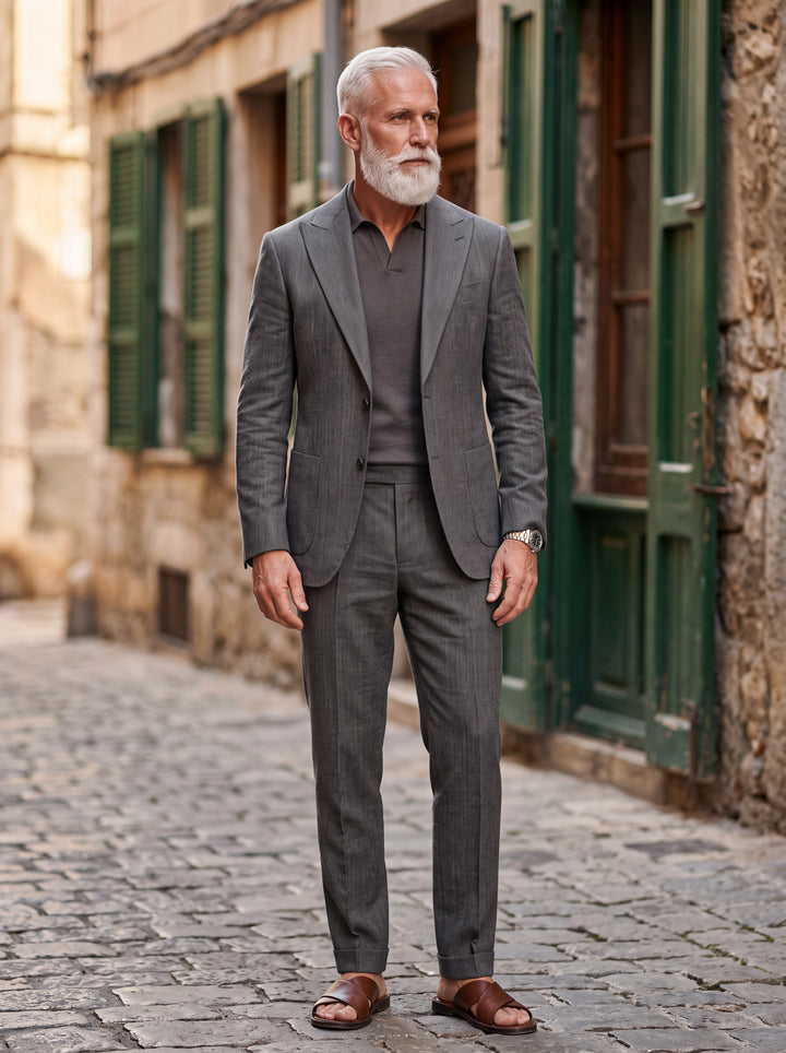 Grant Men two-piece suit in charcoal, worn by a model in a Mediterranean setting - Gentlemens Manor lifestyle