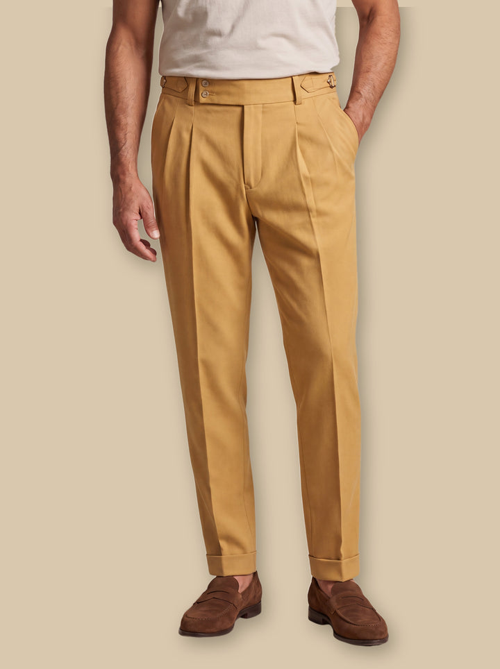Grayson trousers in Mustard, worn by a model on a warm sand studio background - Gentlemens Manor