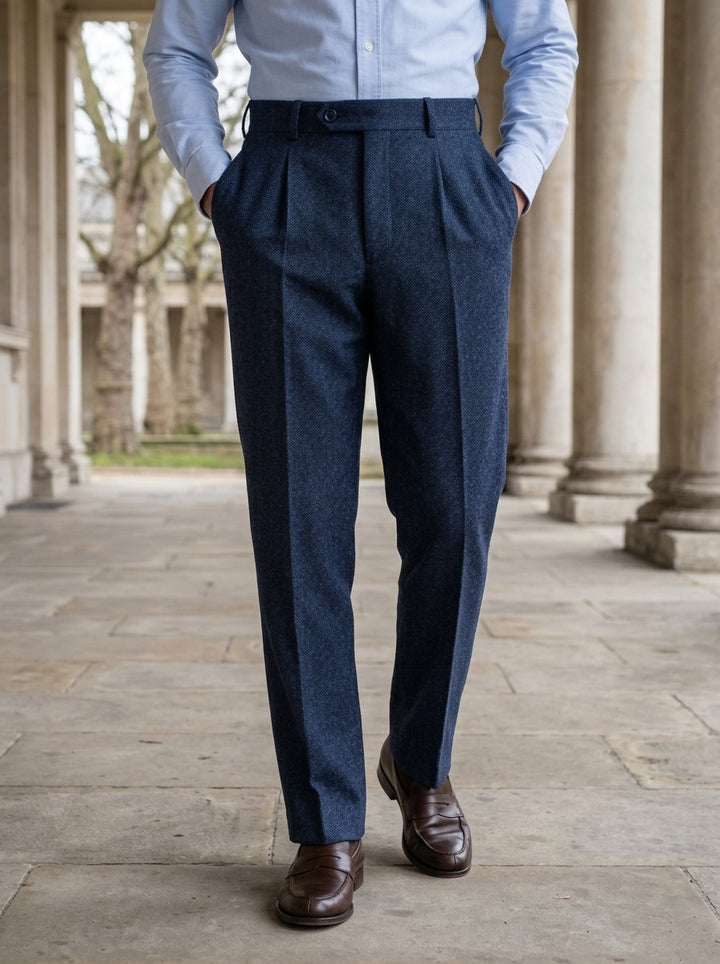 Harcourt herringbone pleated trousers in Navy, lifestyle in a stone colonnade, Gentlemens Manor