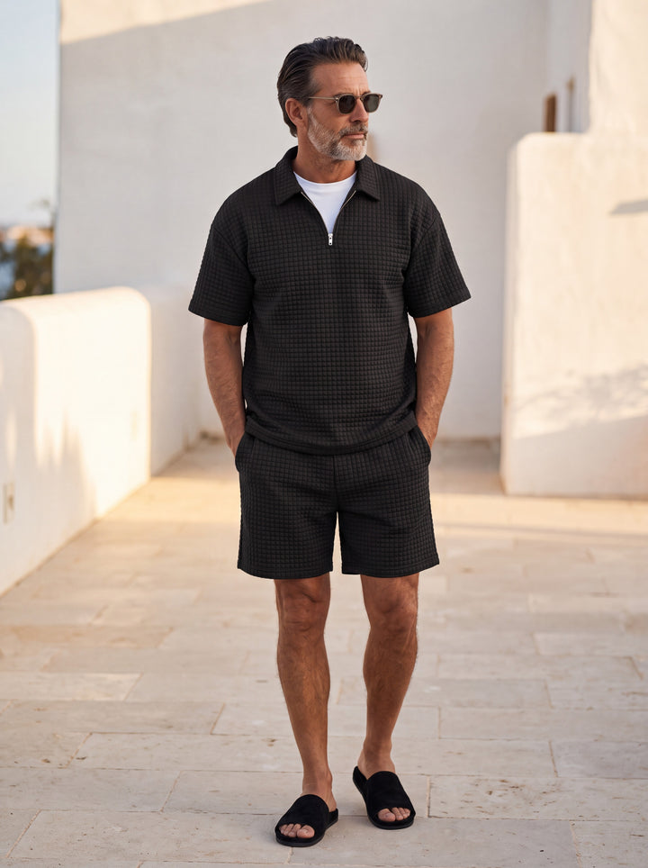 Jasper polo and shorts set in Black, worn by a model in a Mediterranean setting - Gentlemens Manor lifestyle