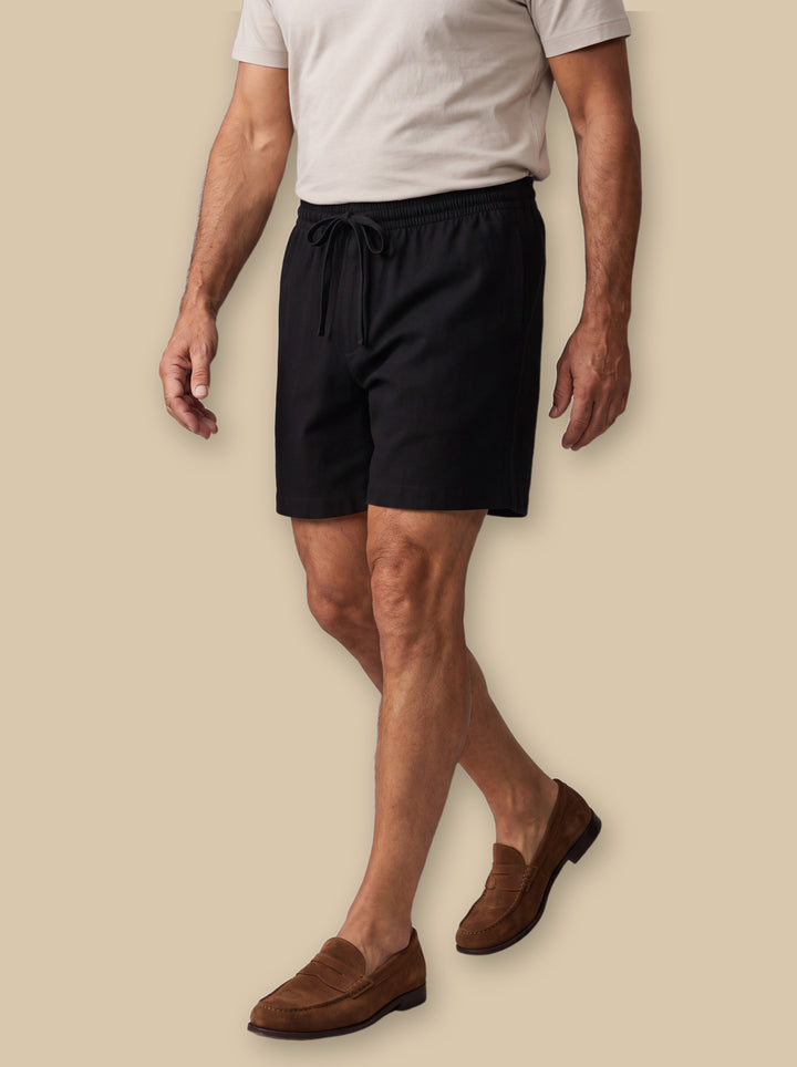 Kane summer shorts in Black, worn by a model on a warm sand studio background - Gentlemens Manor