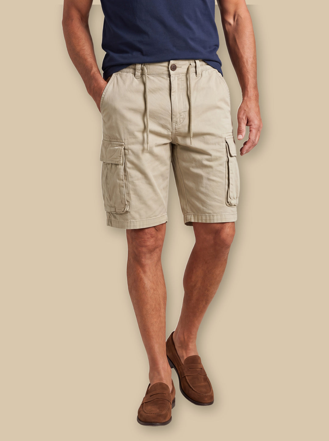 Lawson summer shorts in Sand, worn by a model on a warm sand studio background - Gentlemens Manor