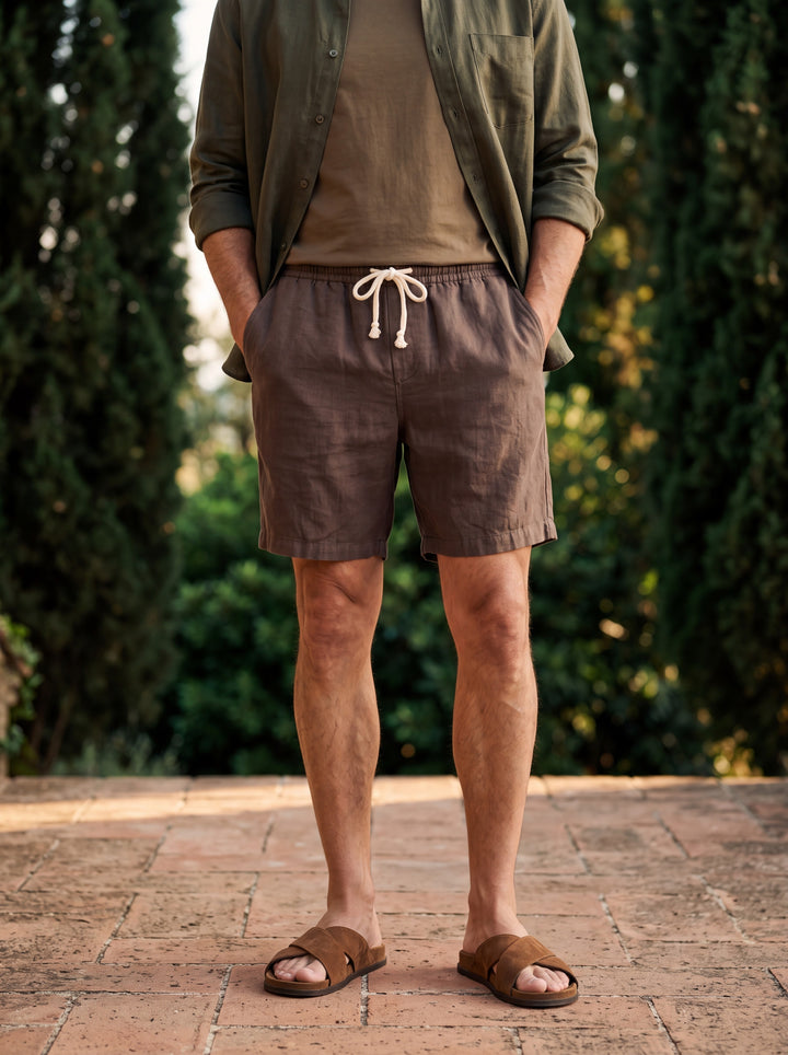 Layton Men beach shorts in brown, worn by a model in a Mediterranean setting - Gentlemens Manor lifestyle