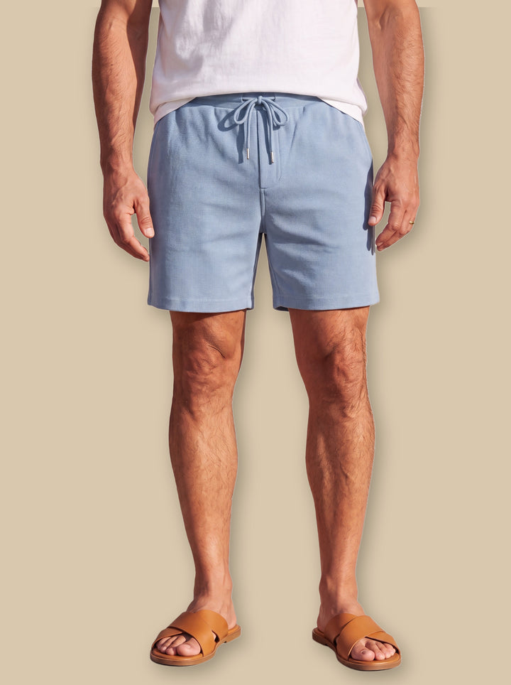 Lemuel summer shorts in Light Blue, worn by a model on a warm sand studio background - Gentlemens Manor