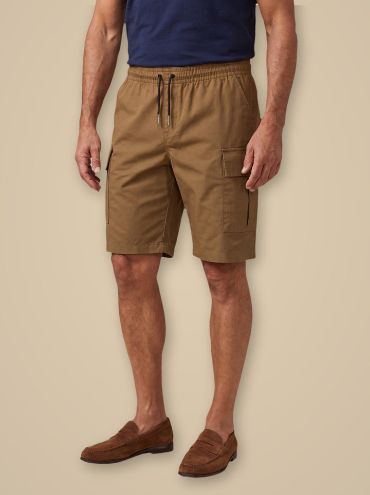 Leo summer shorts in Sand, worn by a model on a warm taupe studio background - Gentlemens Manor