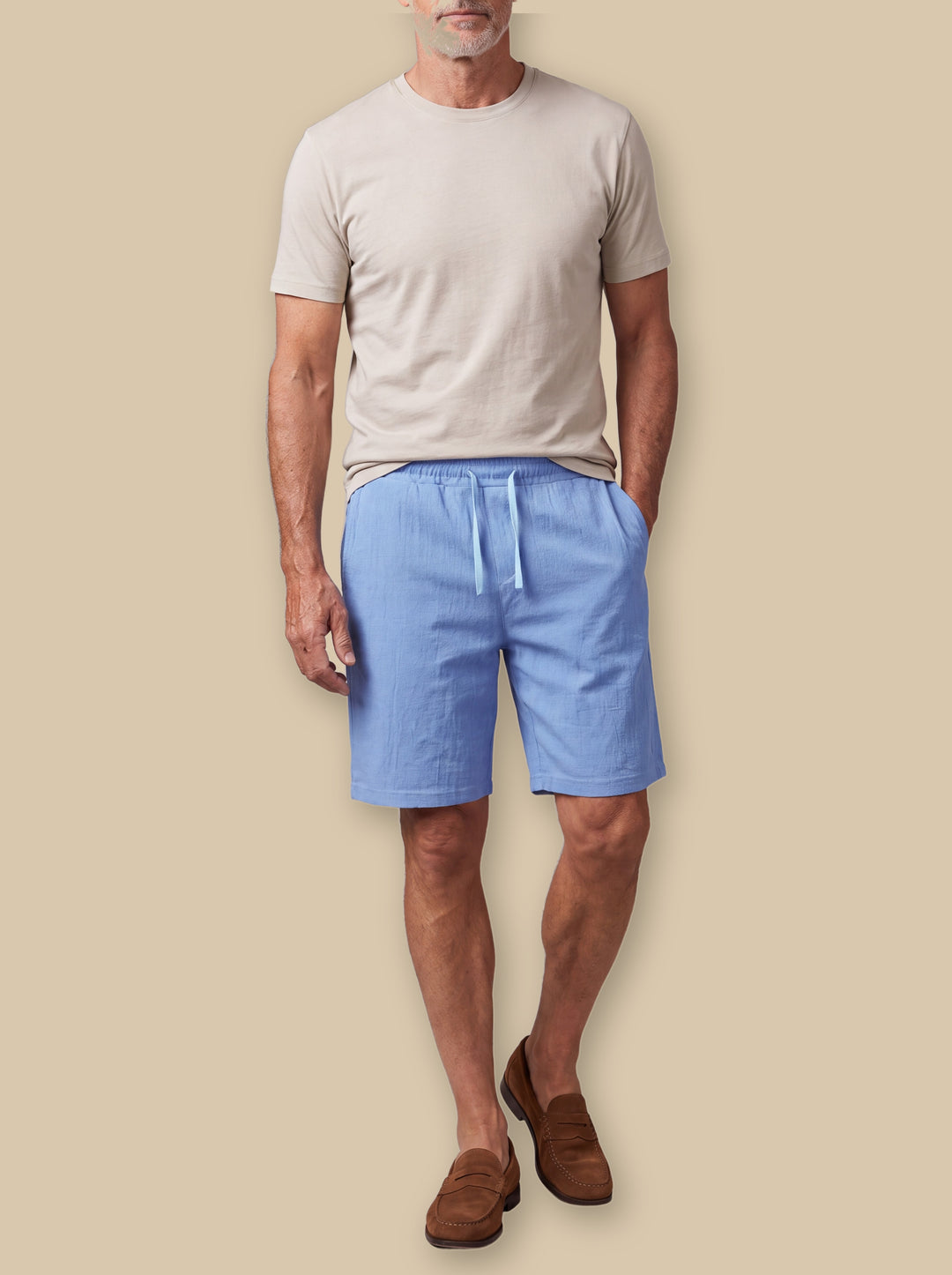 Lewis summer shorts in Blue, worn by a model on a warm sand studio background - Gentlemens Manor