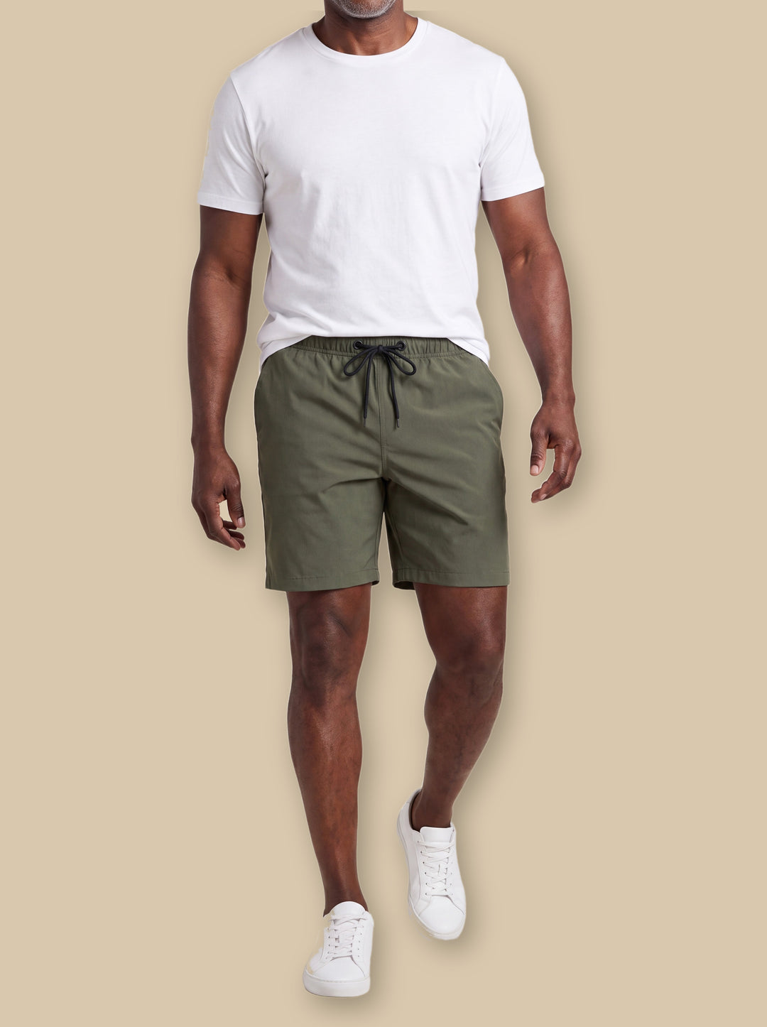 Lloyd summer shorts in Olive, worn by a model on a warm sand studio background - Gentlemens Manor