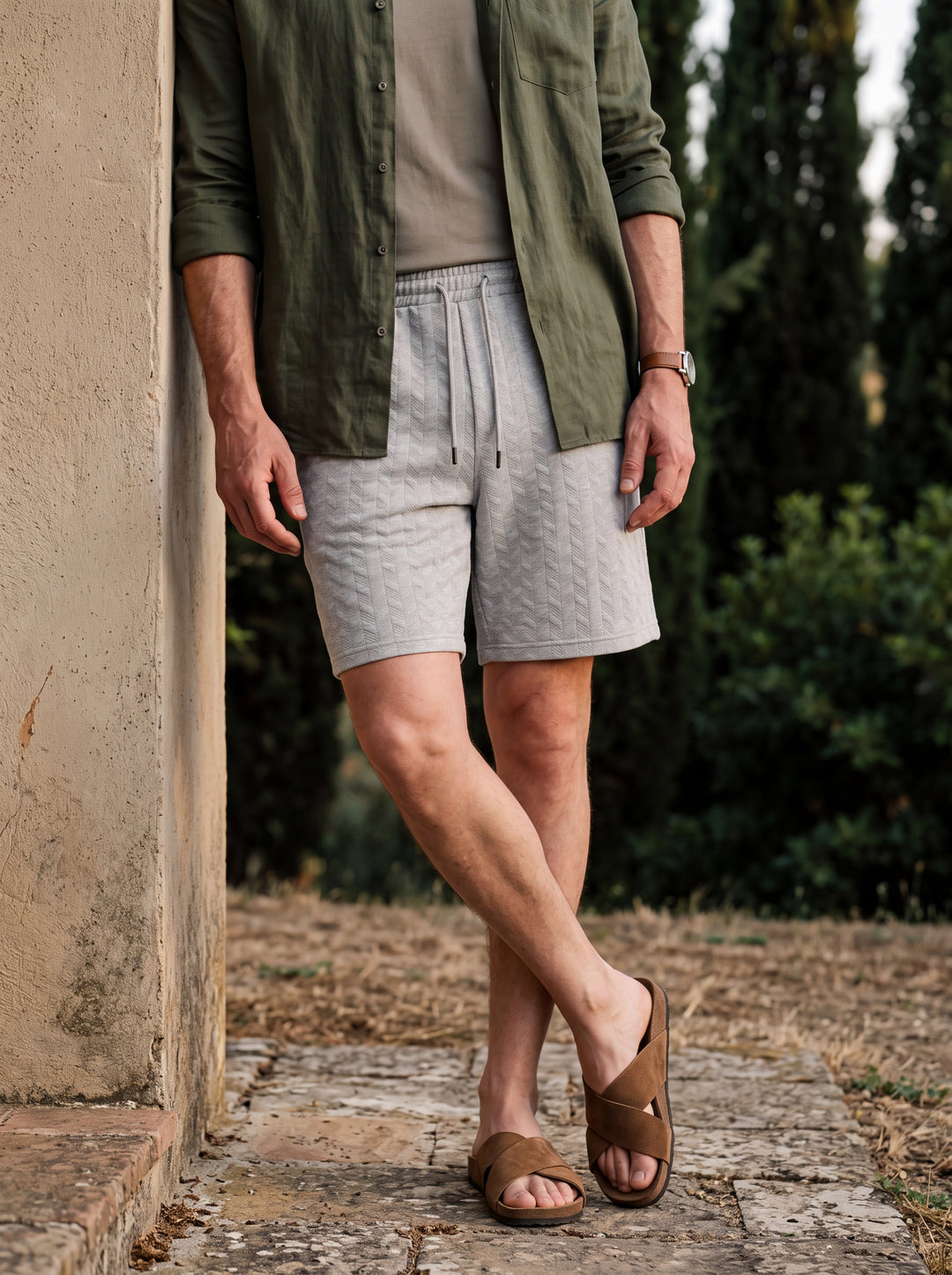 Lucian Men summer shorts in light grey, worn by a model in a Mediterranean setting - Gentlemens Manor lifestyle
