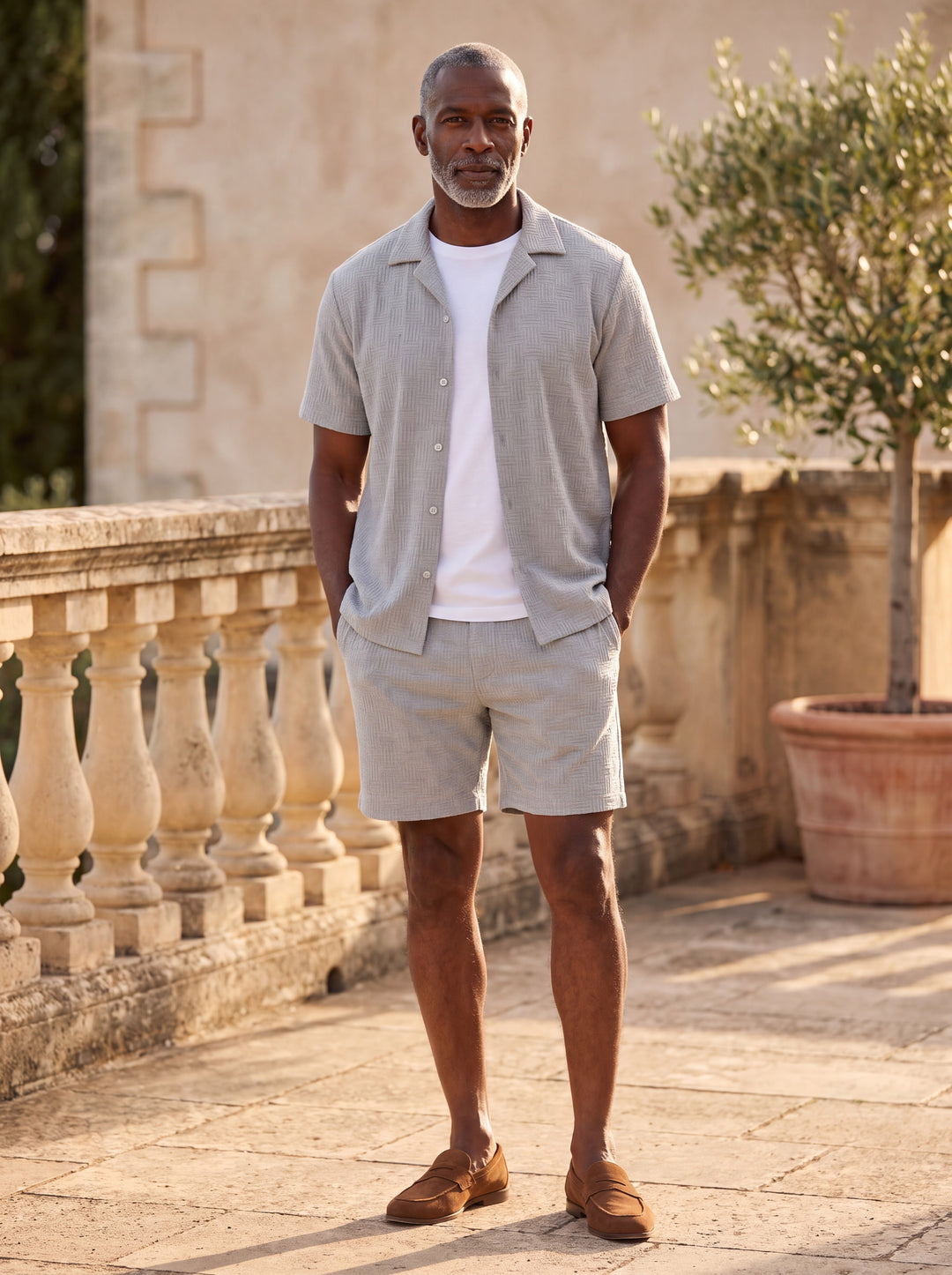 Maxwell Men two piece set in grey, worn by a model on a Mediterranean terrace - Gentlemens Manor lifestyle