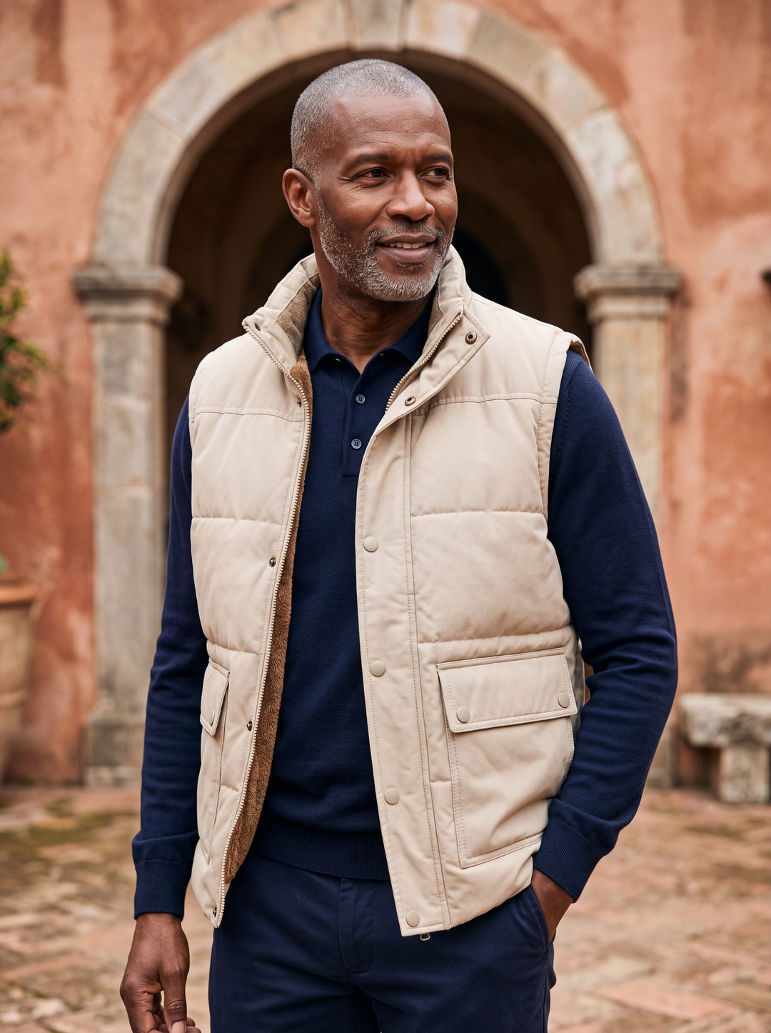 Ned vest in Sand, worn by a model in a Mediterranean setting - Gentlemens Manor lifestyle