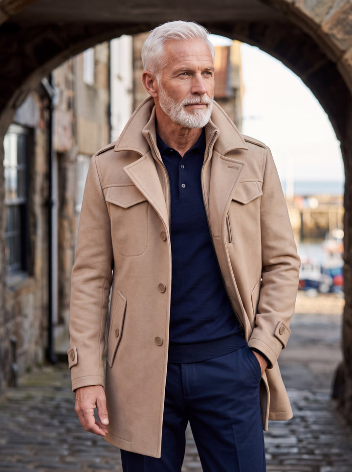 Orin coat in Sand, worn by a model in a Mediterranean setting - Gentlemens Manor lifestyle