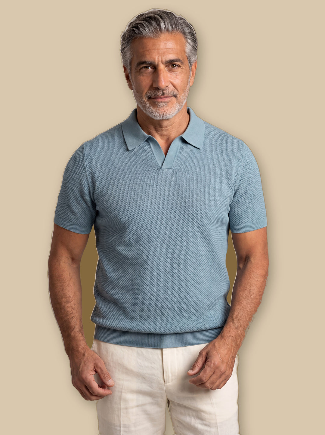 Oswald polo shirt in Blue, worn by a model on a warm sand studio background - Gentlemens Manor
