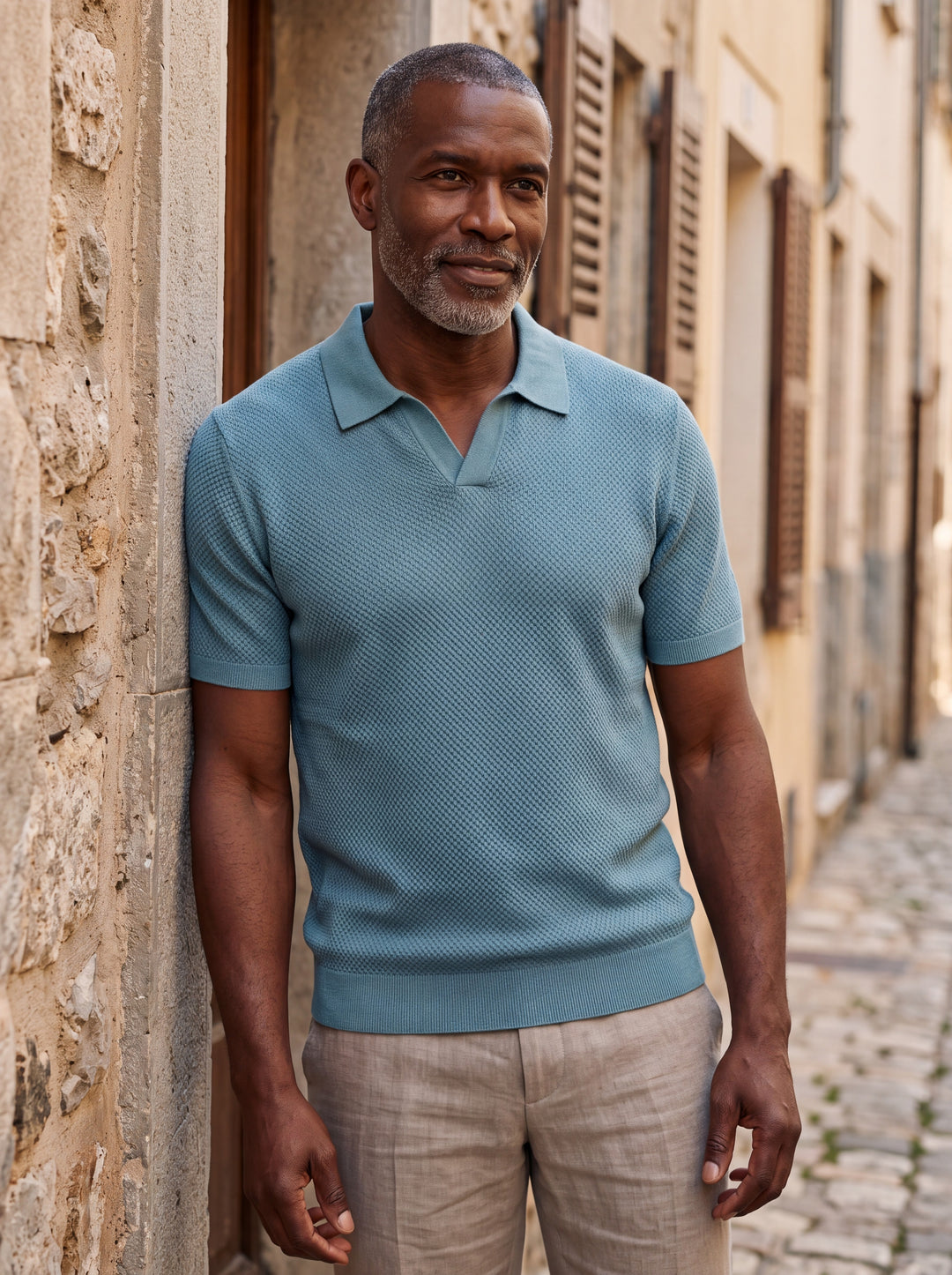Oswald Men polo shirt in blue, worn by a model on a Mediterranean terrace - Gentlemens Manor lifestyle