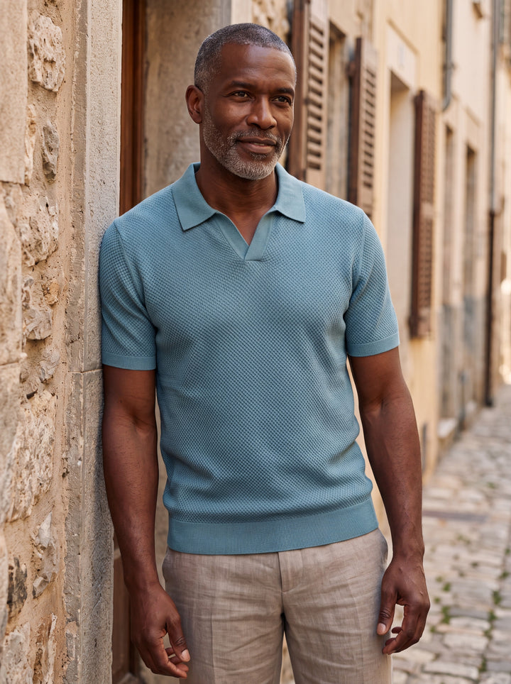 Oswald Men polo shirt in blue, worn by a model on a Mediterranean terrace - Gentlemens Manor lifestyle