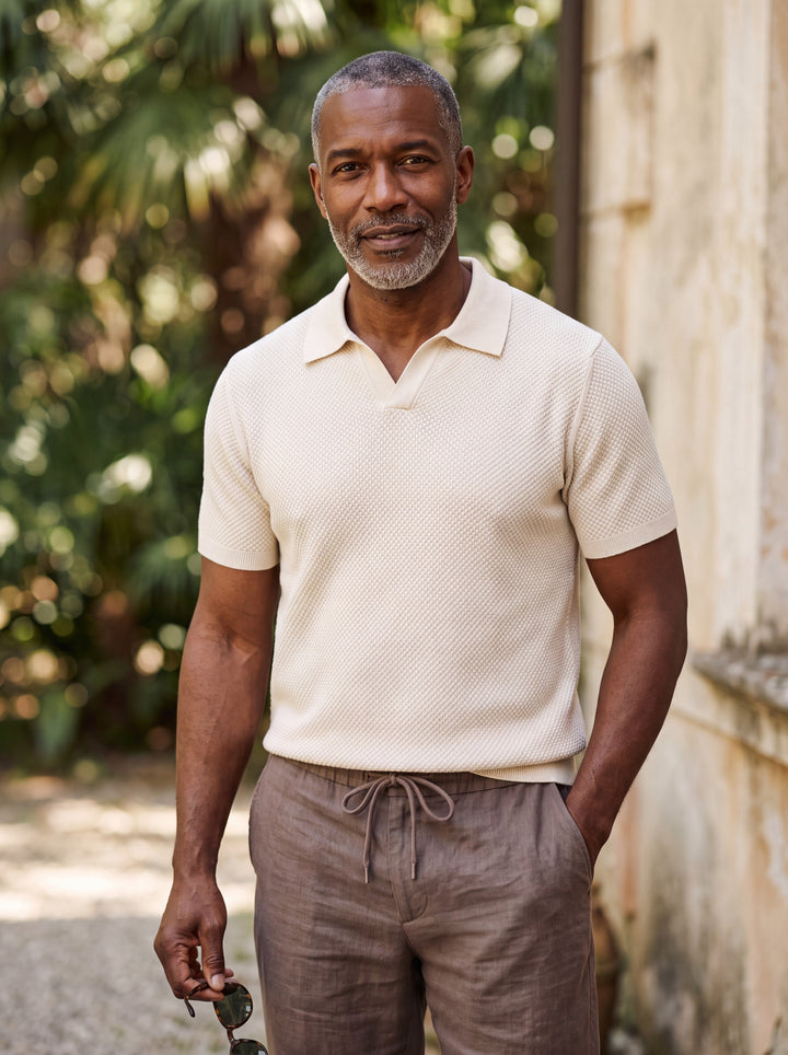 Oswald Men polo shirt in cream, worn by a model on a Mediterranean terrace - Gentlemens Manor lifestyle