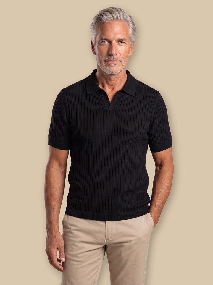 Owen polo shirt in Black, worn by a model on a warm sand studio background - Gentlemens Manor
