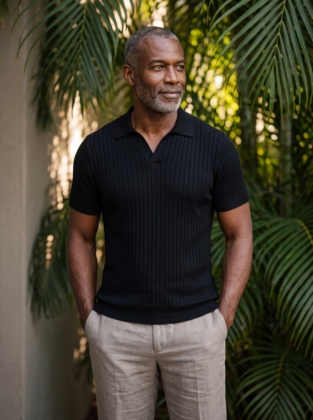 Owen Men polo shirt in black, worn by a model on a Mediterranean terrace - Gentlemens Manor lifestyle