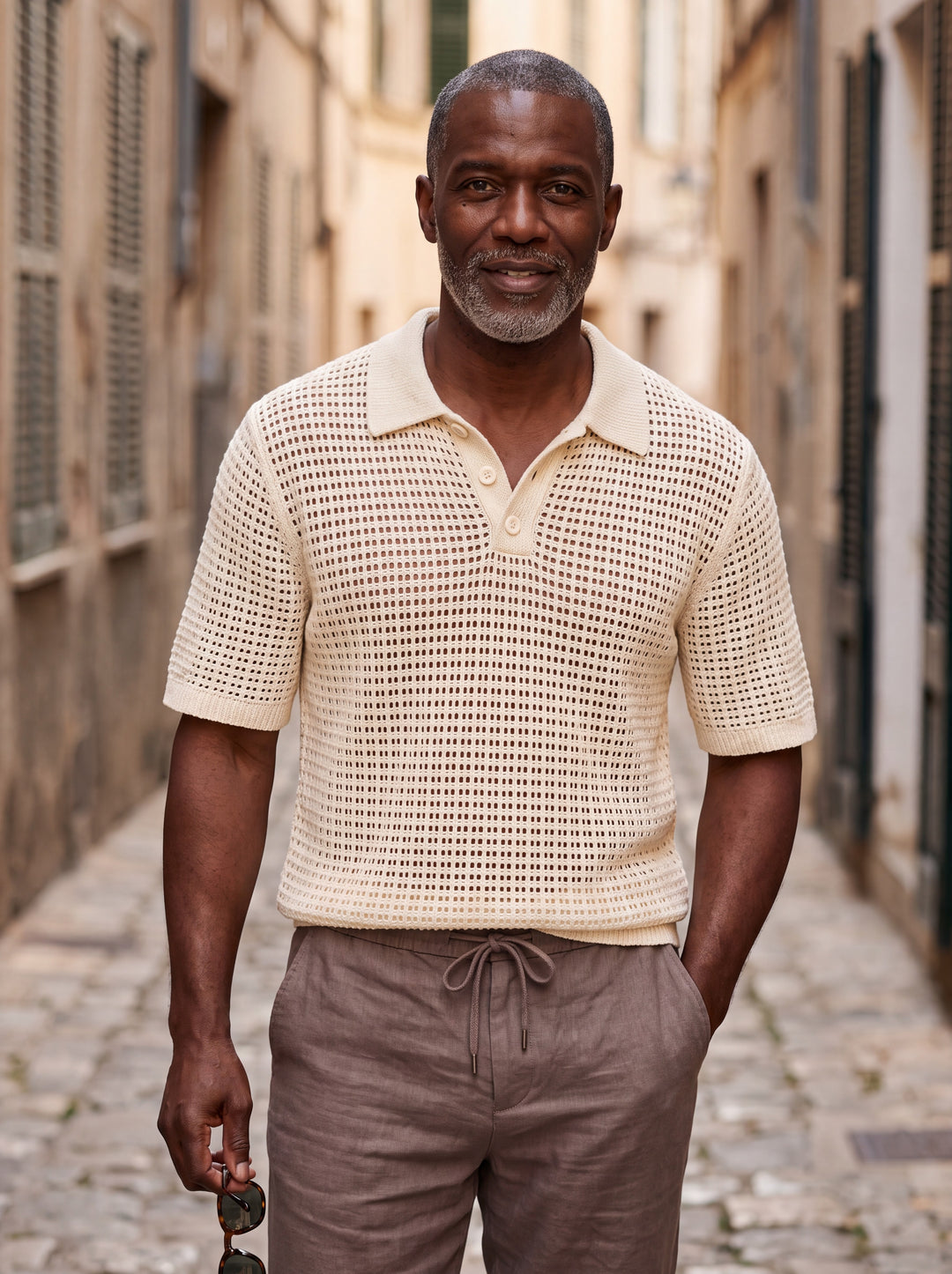 Palmer Men polo shirt in beige, worn by a model on a Mediterranean terrace - Gentlemens Manor lifestyle