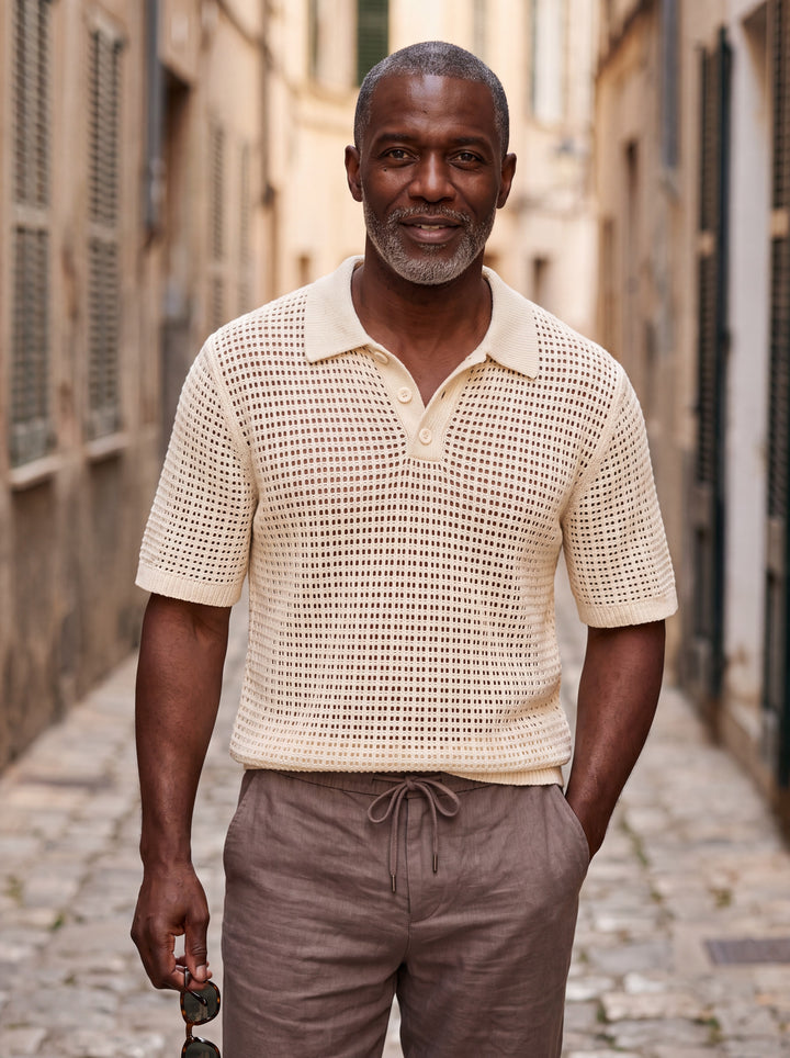 Palmer Men polo shirt in beige, worn by a model on a Mediterranean terrace - Gentlemens Manor lifestyle