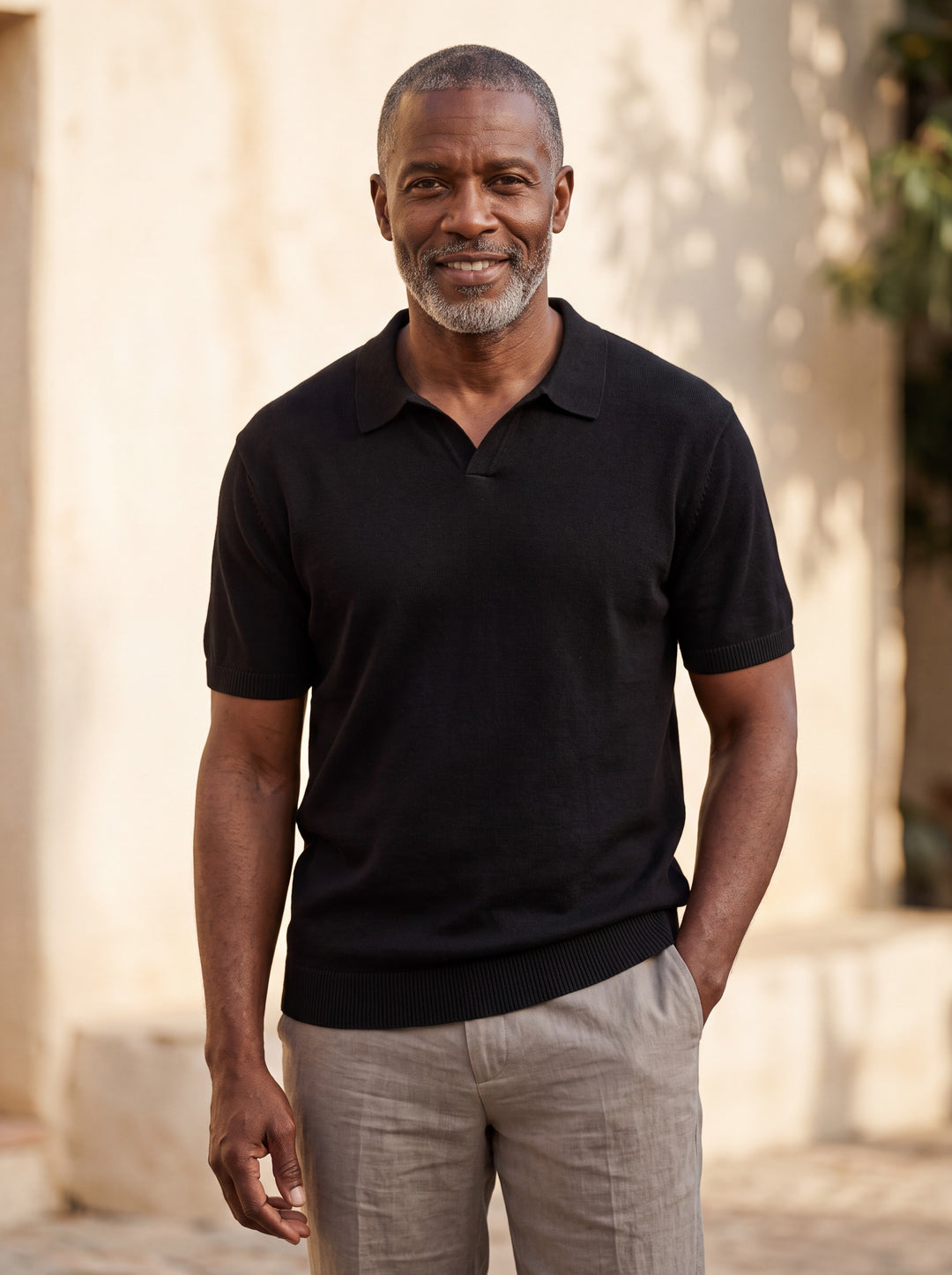 Palmer Men polo shirt in black, worn by a model on a Mediterranean terrace - Gentlemens Manor lifestyle
