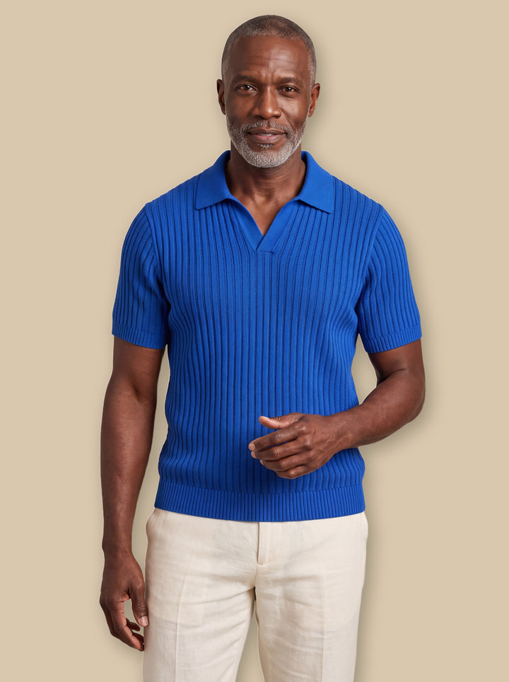 Palmer polo shirt in Blue, worn by a model on a warm sand studio background - Gentlemens Manor