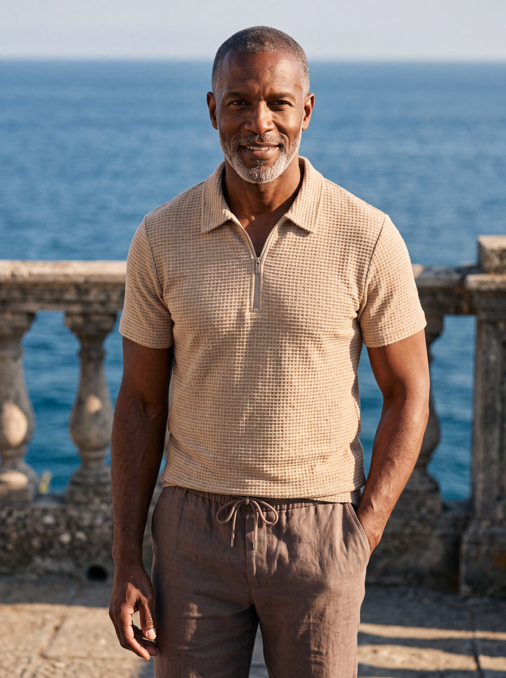 Parker Men polo shirt in sand, worn by a model on a Mediterranean terrace - Gentlemens Manor lifestyle