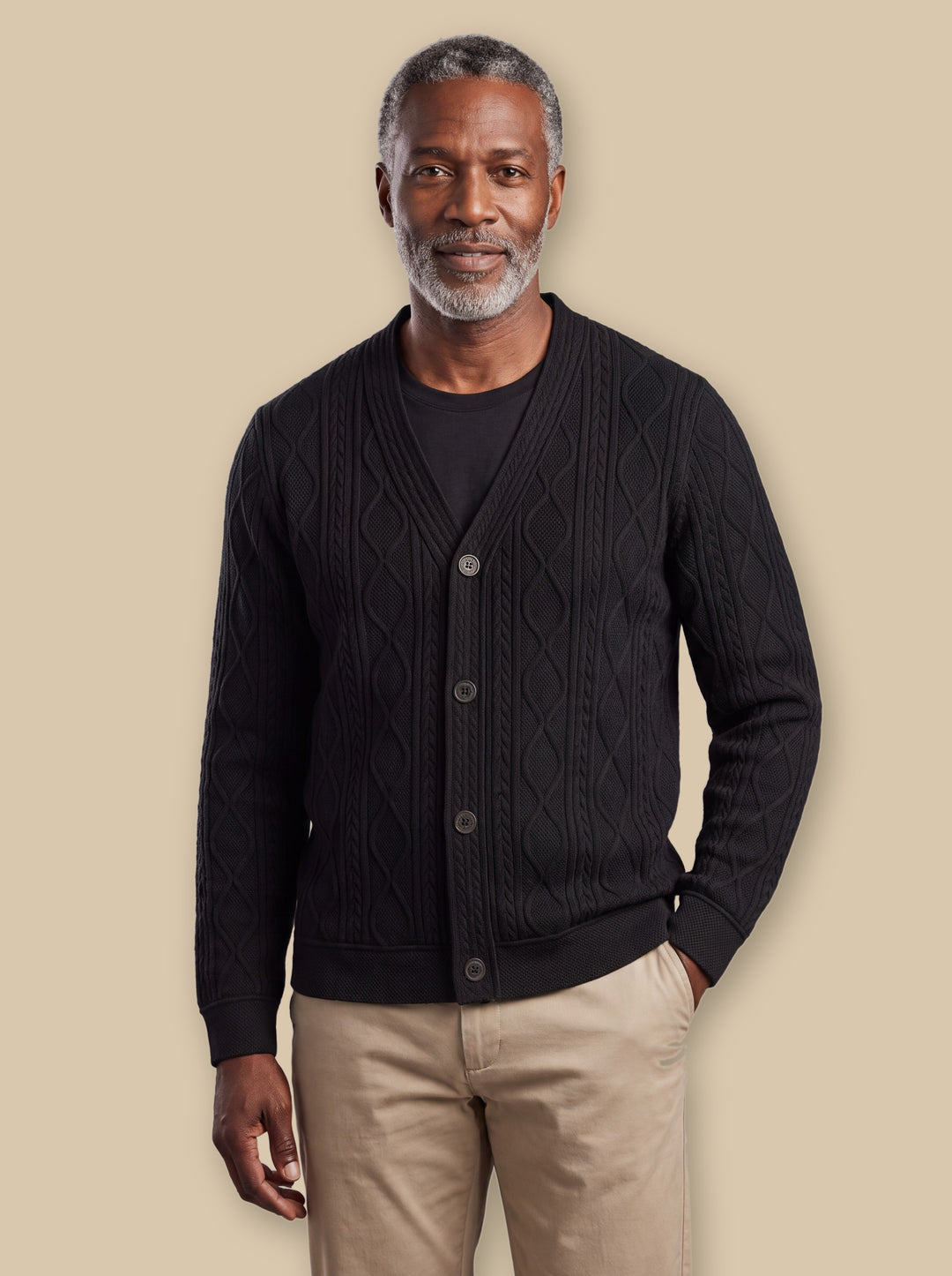 Prentice knit sweater in Black, worn by a model on a warm sand studio background - Gentlemens Manor