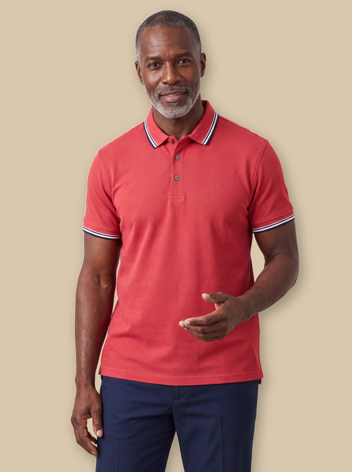 Preston polo shirt in Burgundy, worn by a model on a warm sand studio background - Gentlemens Manor