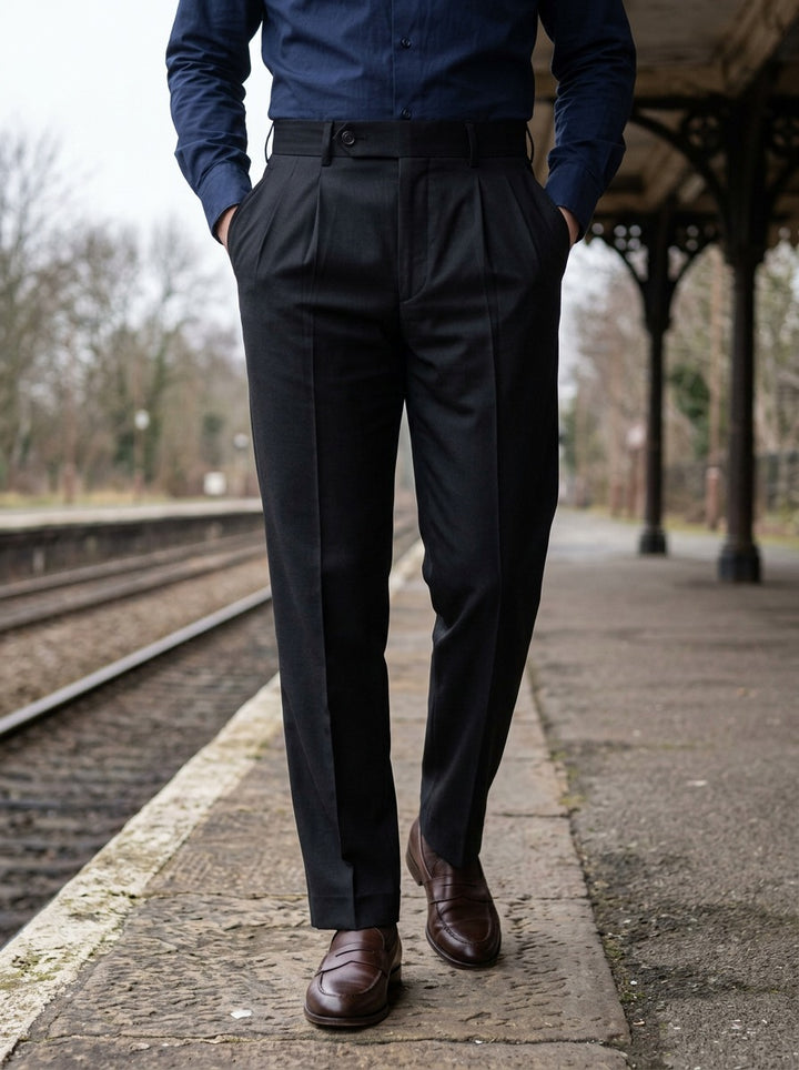 Prewitt button tab trousers in Black, lifestyle on a railway platform, Gentlemens Manor