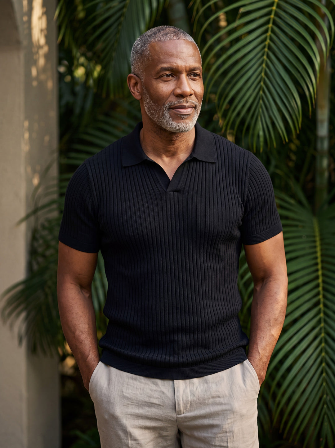 Quentin Men polo shirt in black, worn by a model on a Mediterranean terrace - Gentlemens Manor lifestyle