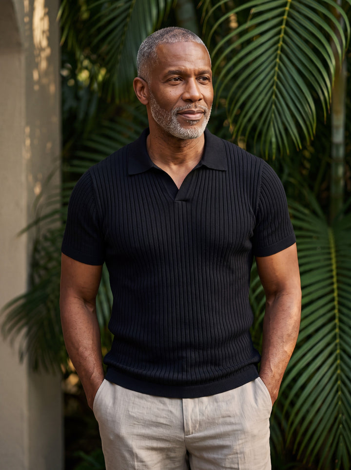Quentin Men polo shirt in black, worn by a model on a Mediterranean terrace - Gentlemens Manor lifestyle