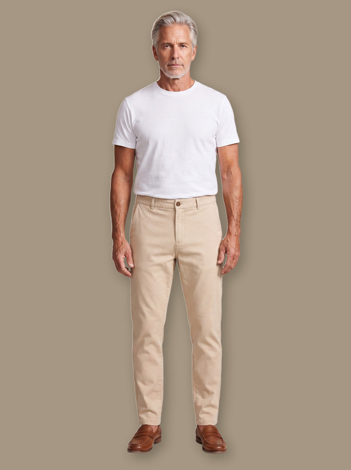 Quinton trousers in Beige, worn by a model on a warm taupe studio background - Gentlemens Manor