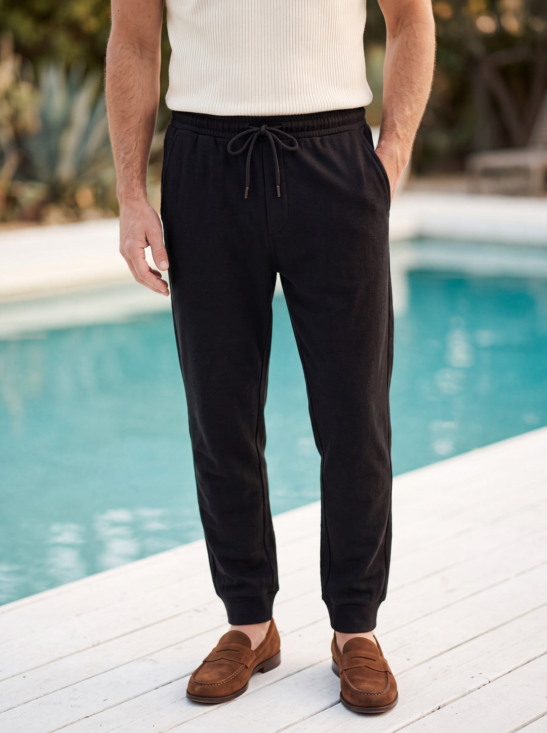 Raleigh trousers in Black, worn by a model in a Mediterranean setting - Gentlemens Manor lifestyle