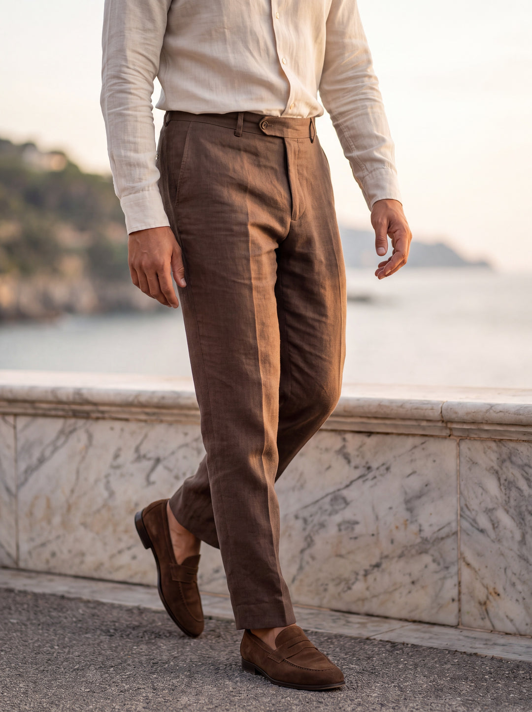 Robert Men trousers in brown, worn by a model on a Mediterranean terrace - Gentlemens Manor lifestyle